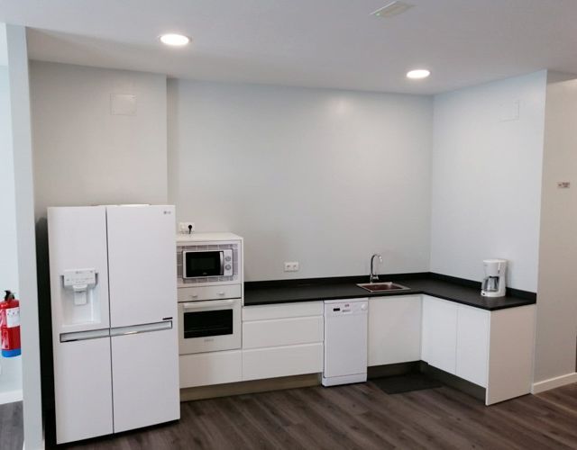 Una cocina con nevera y microondas