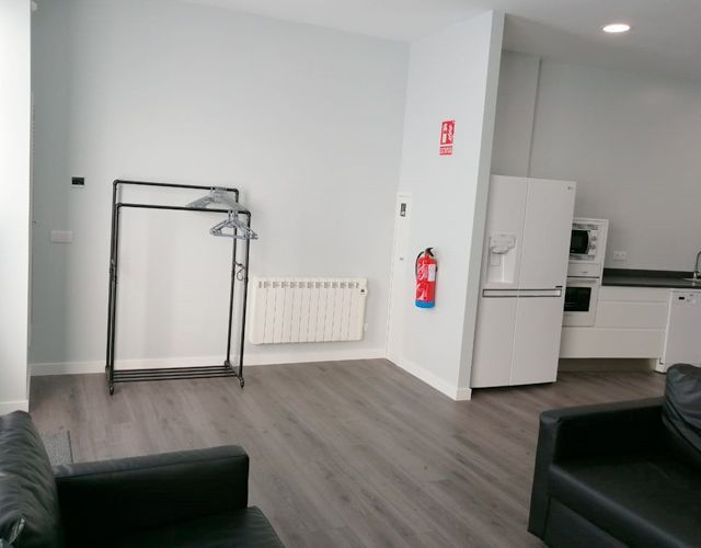 Una sala de estar con un sofá y un extintor en la pared.