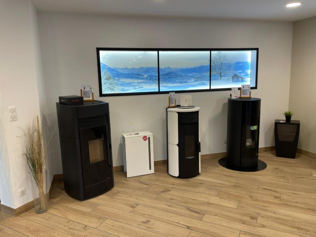 Salle d'exposition de cheminées présentant différents poêles à granulés.