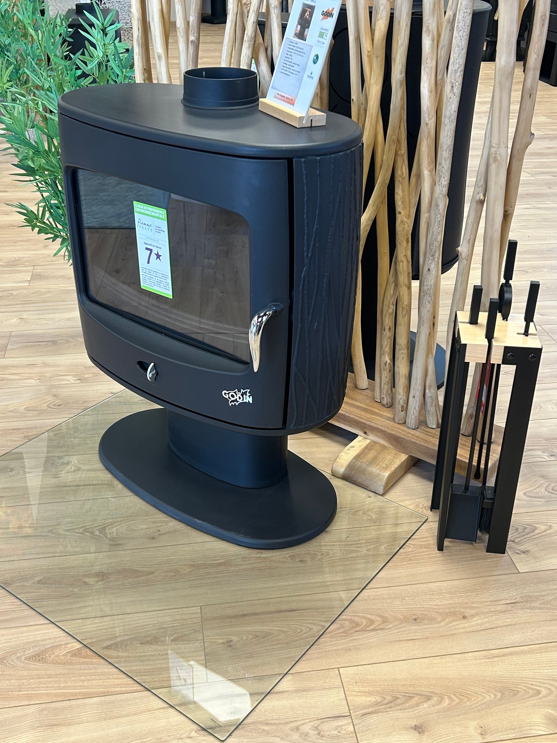 Ensemble d'accessoires de cheminée en métal gris sur gazon artificiel vert.