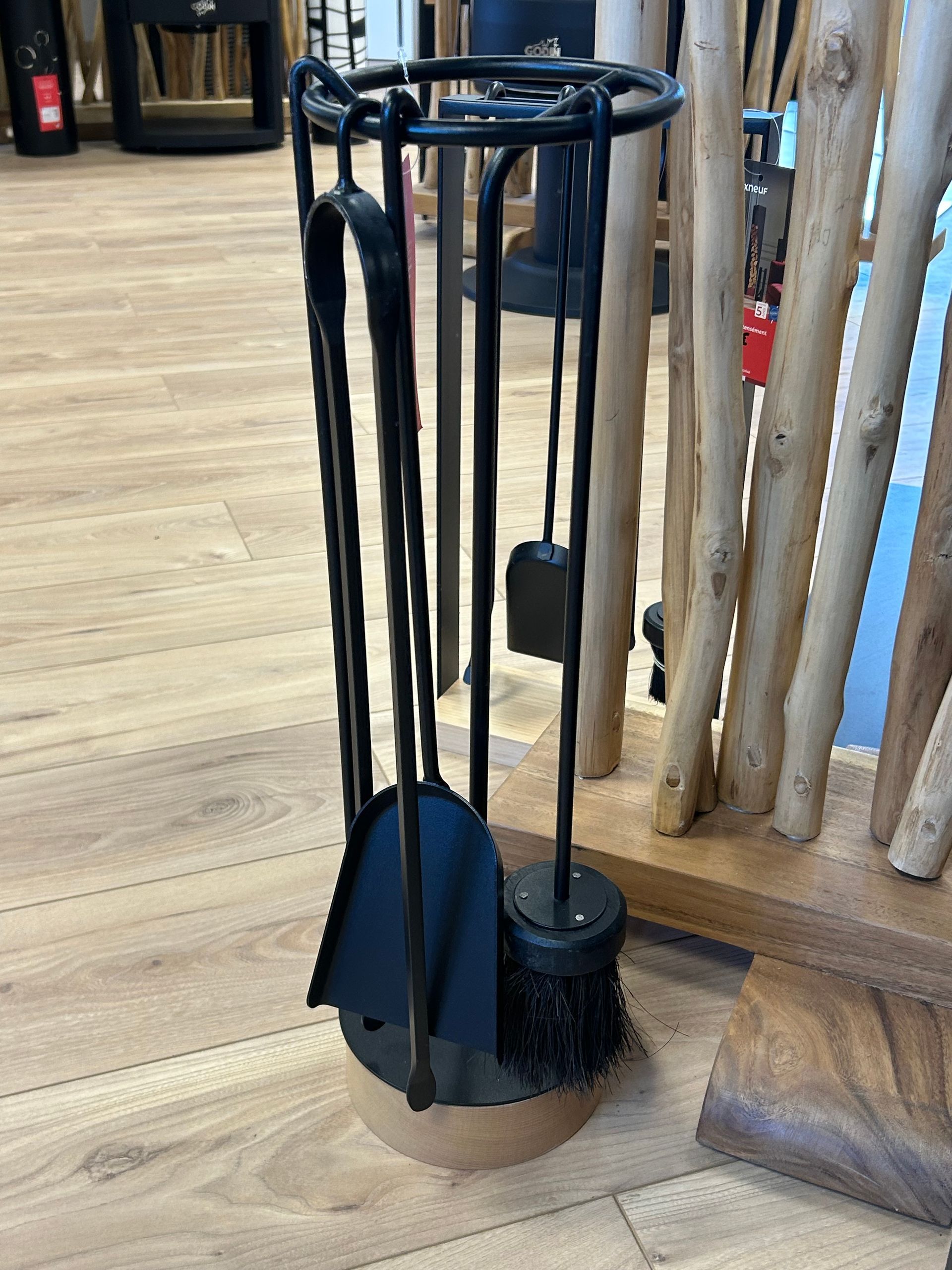 Ensemble d'outils de cheminée sur fond vert. Comprend une pelle, un tisonnier et un balai.