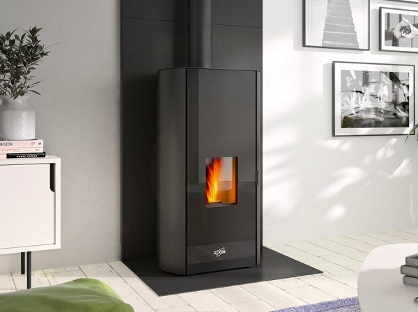 Salle d'exposition de cheminées présentant divers poêles noirs, dont un modèle rond avec cheminée.