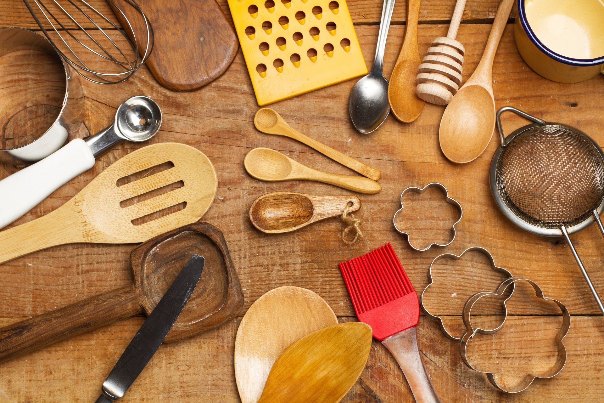 Una mesa de madera cubierta con una variedad de utensilios de cocina.