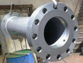 Un gran tubo de metal con agujeros está sobre una mesa de madera.