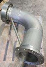 Un tubo de metal está sobre una mesa de madera.