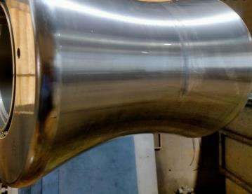 Un gran tubo de acero inoxidable se encuentra sobre una mesa en una habitación.