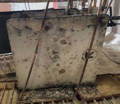 Un trozo de metal sucio se encuentra encima de una mesa de madera.