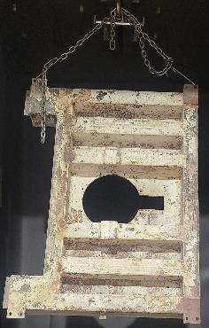 Un trozo de madera con un agujero en el medio cuelga de una cadena.