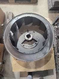 Un gran ventilador de acero inoxidable está sobre una mesa de madera.