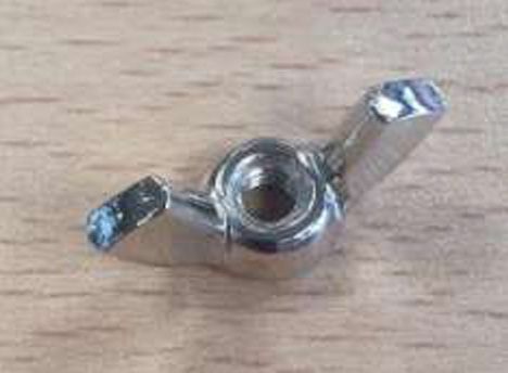 Un primer plano de una tuerca de metal sobre una mesa de madera.