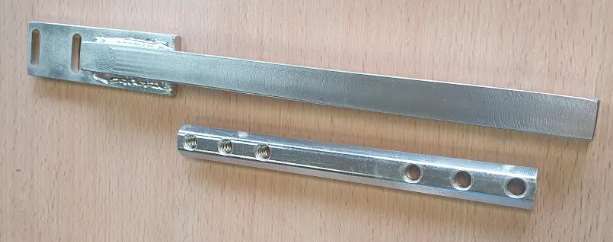 Dos piezas de metal están sobre una mesa de madera.