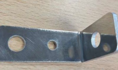 Un soporte de metal con agujeros está sobre una mesa de madera.