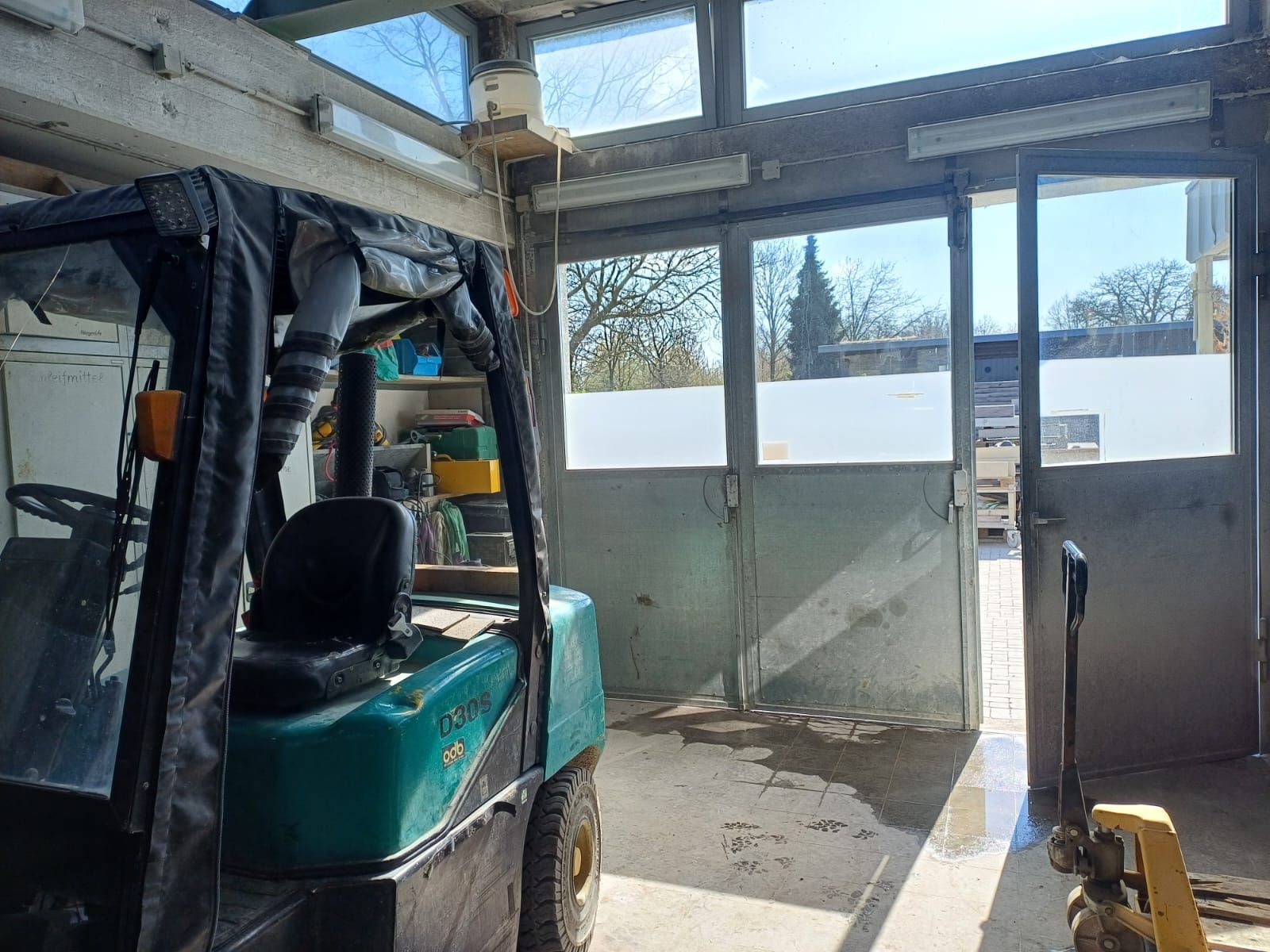 Ein Gabelstapler steht in einer Garage neben einer Tür.