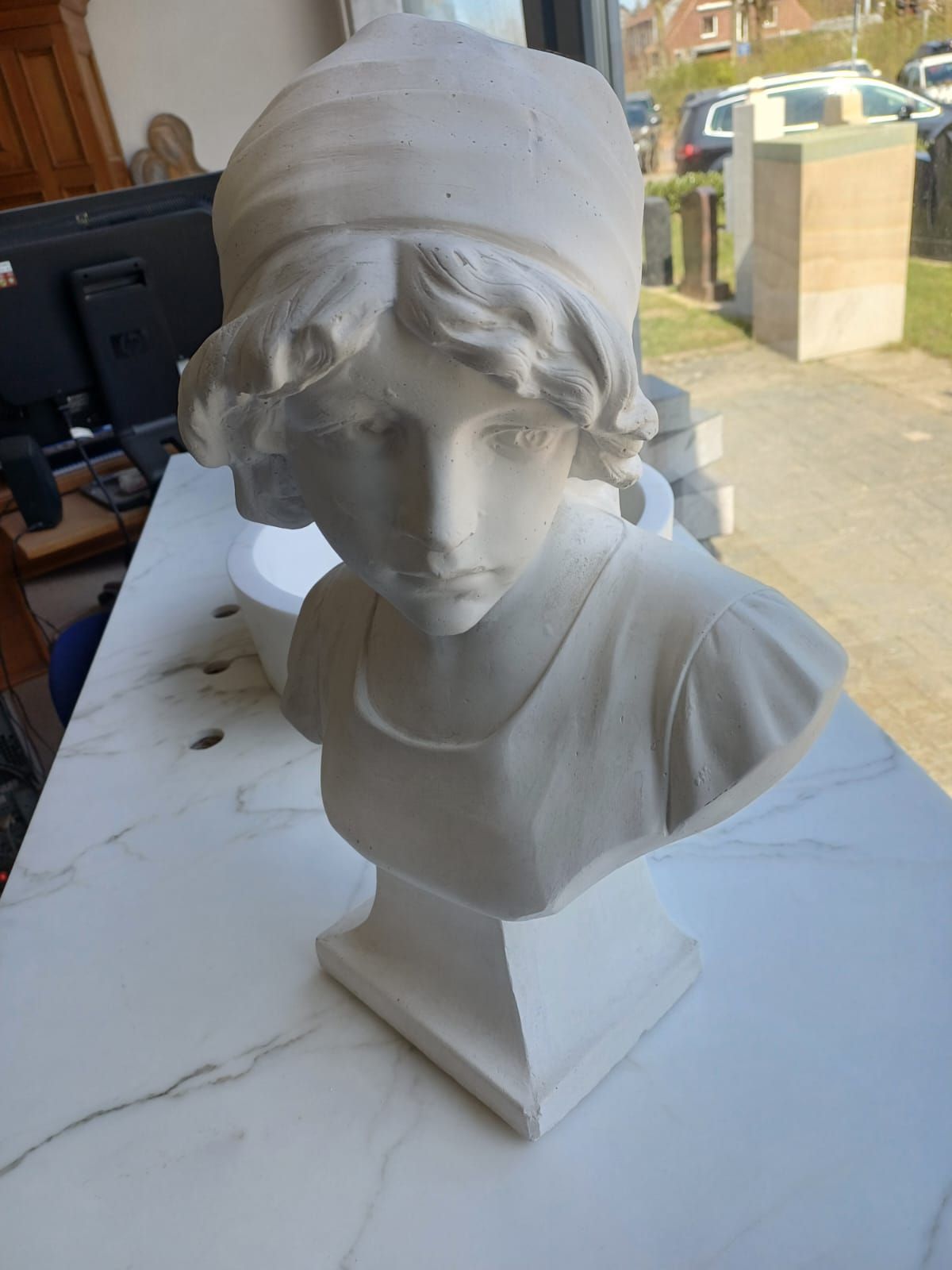 Eine Statue eines Frauenkopfes sitzt auf einem Tisch