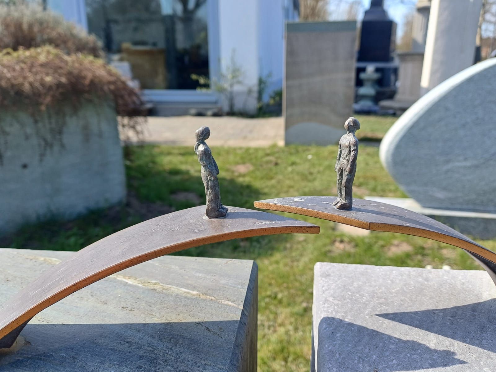 Eine Statue von zwei Menschen, die auf einer Holzbrücke stehen.