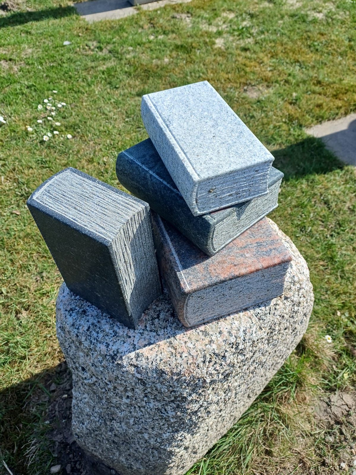 Ein Stapel Bücher, die übereinander auf einem Felsen liegen.