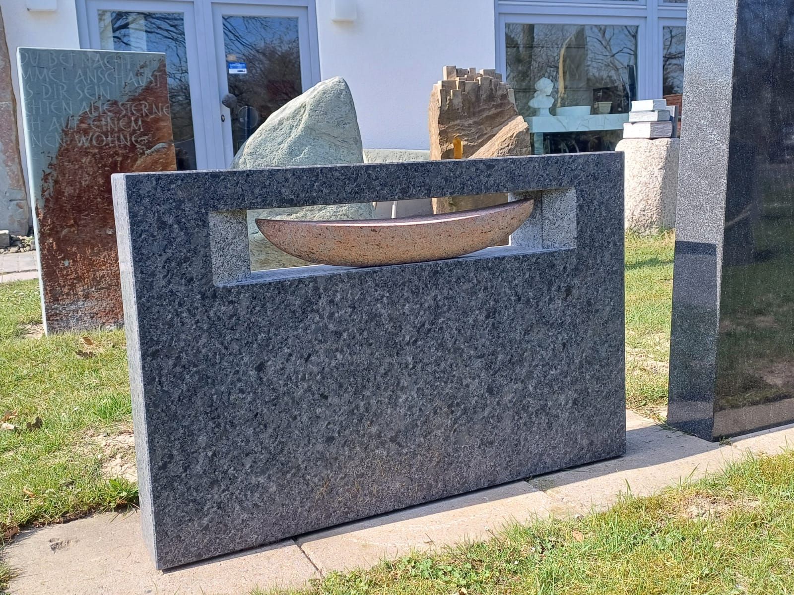 Ein Grabstein mit einem Boot in der Mitte.