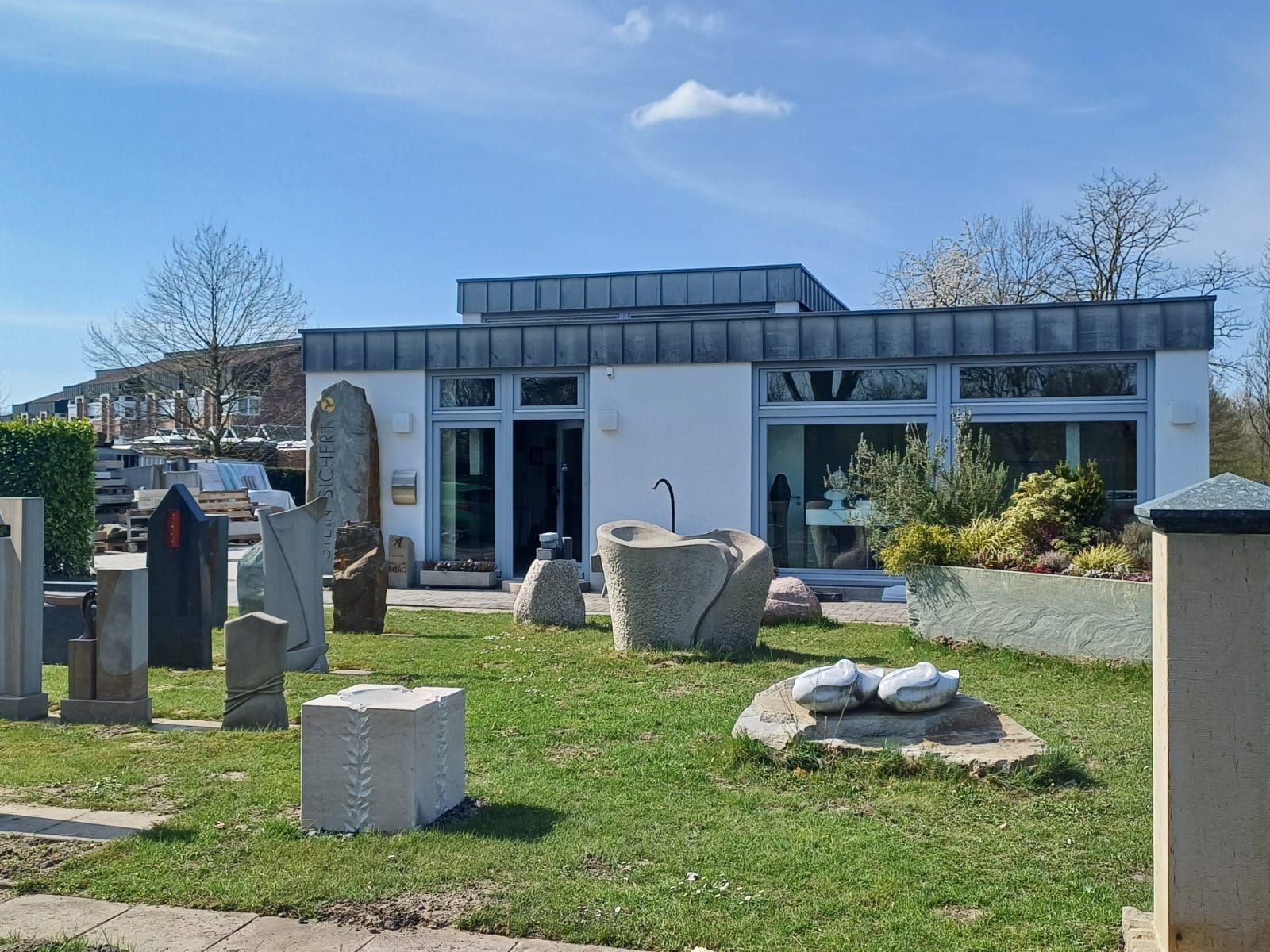 Ein weißes Gebäude mit vielen Statuen davor.