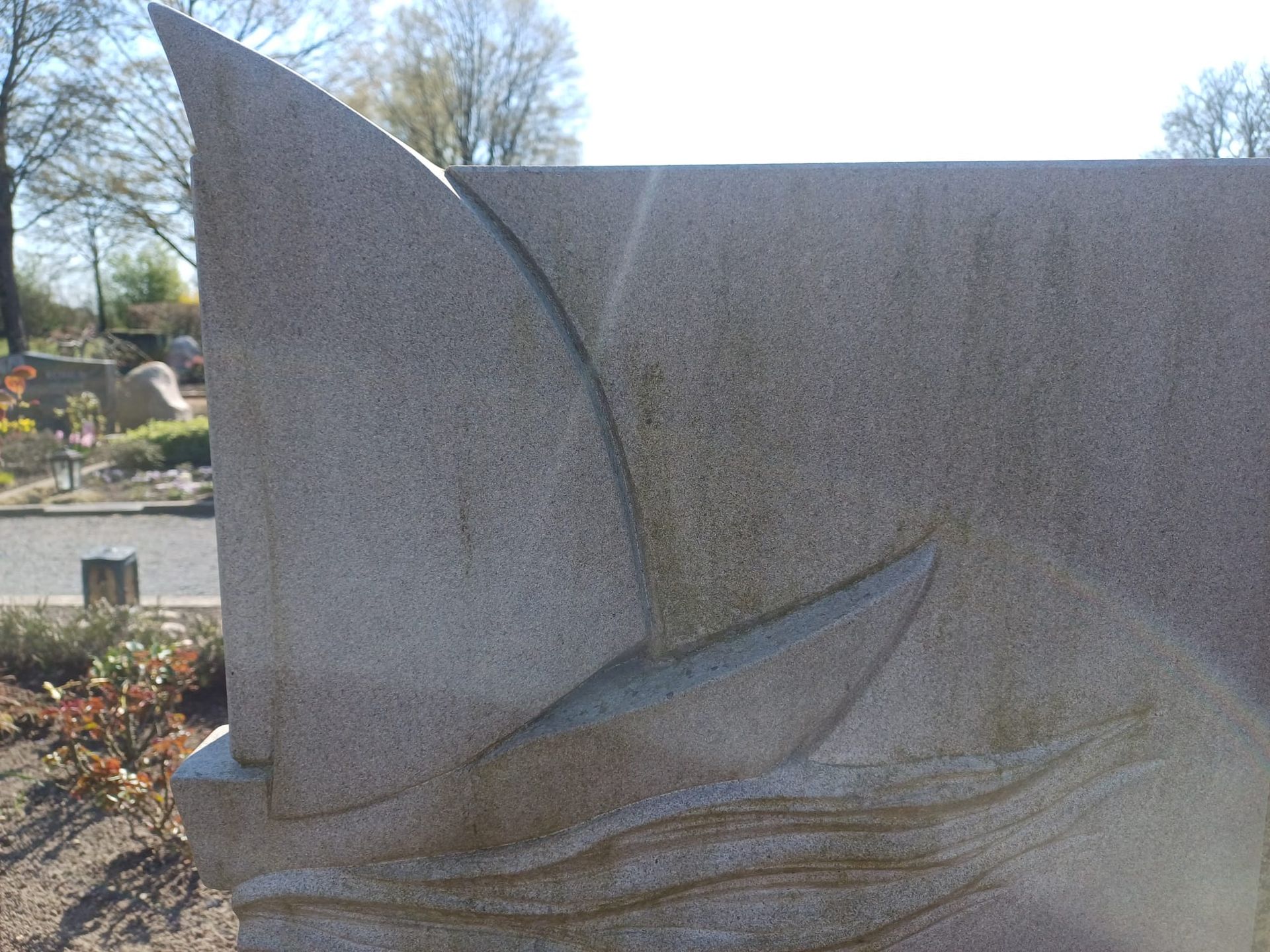 Eine Statue eines Segelbootes auf einem Felsen auf einem Friedhof