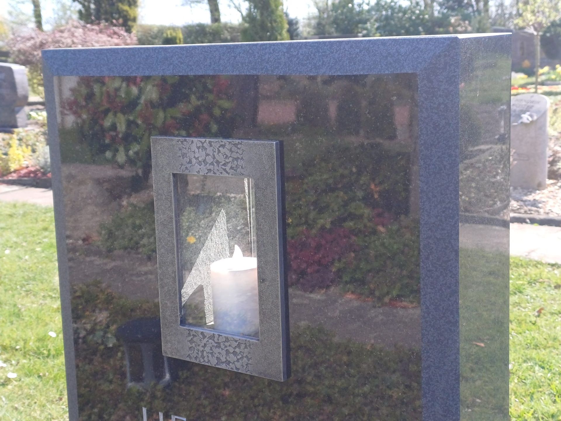 ein Grabstein mit eingelassener Kerze 