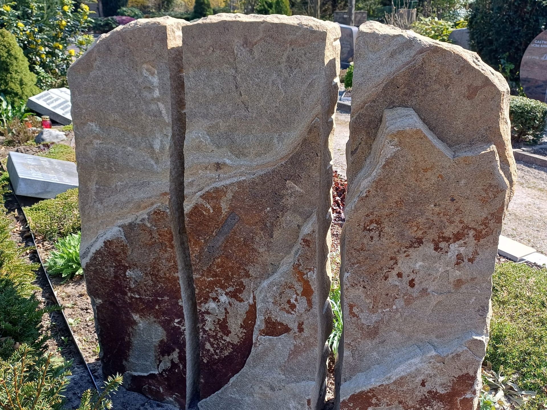 Auf einem Friedhof steht eine große Steinskulptur.