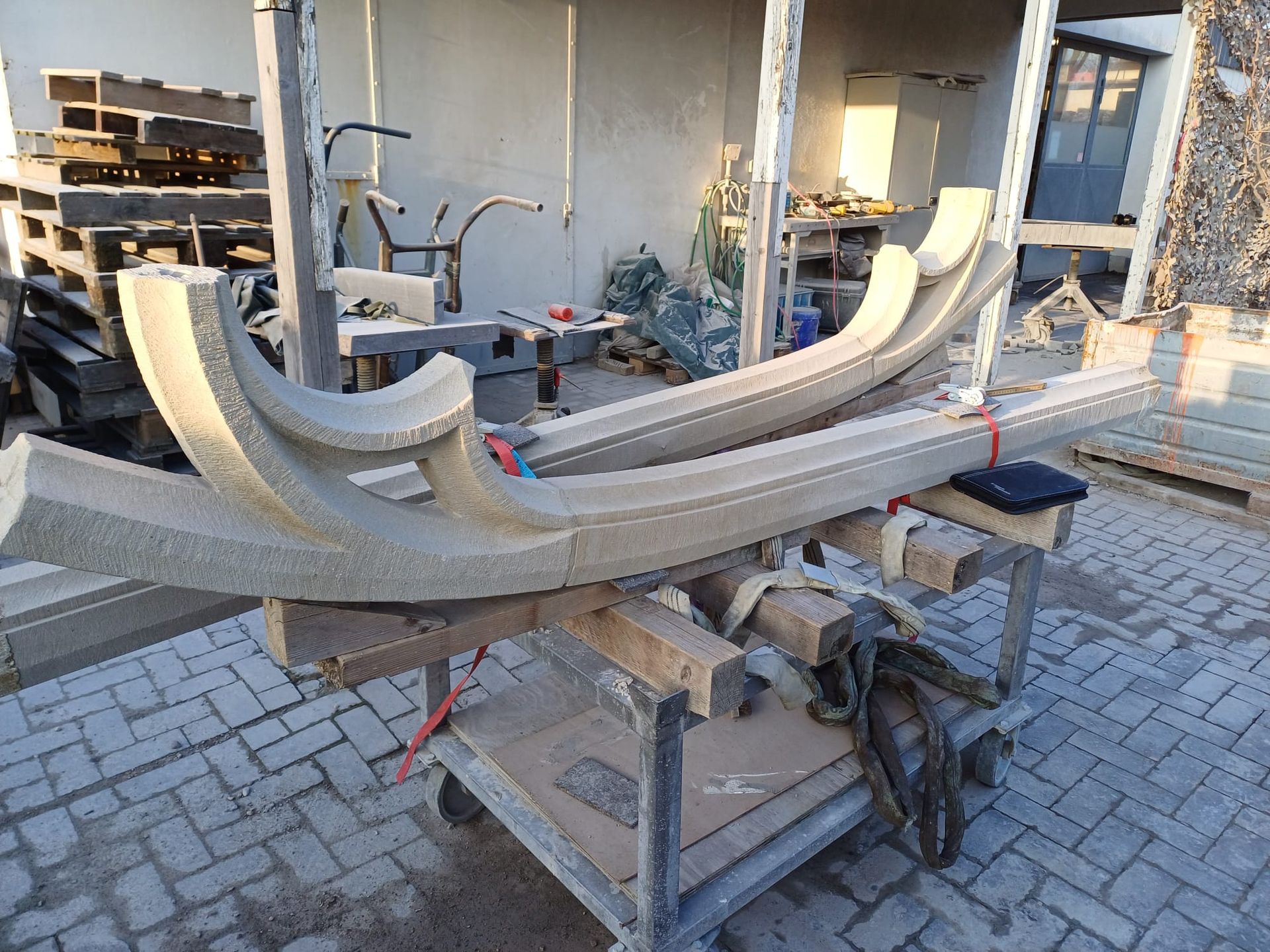 Auf einem Tisch liegt ein halber gotischer Steinbogen