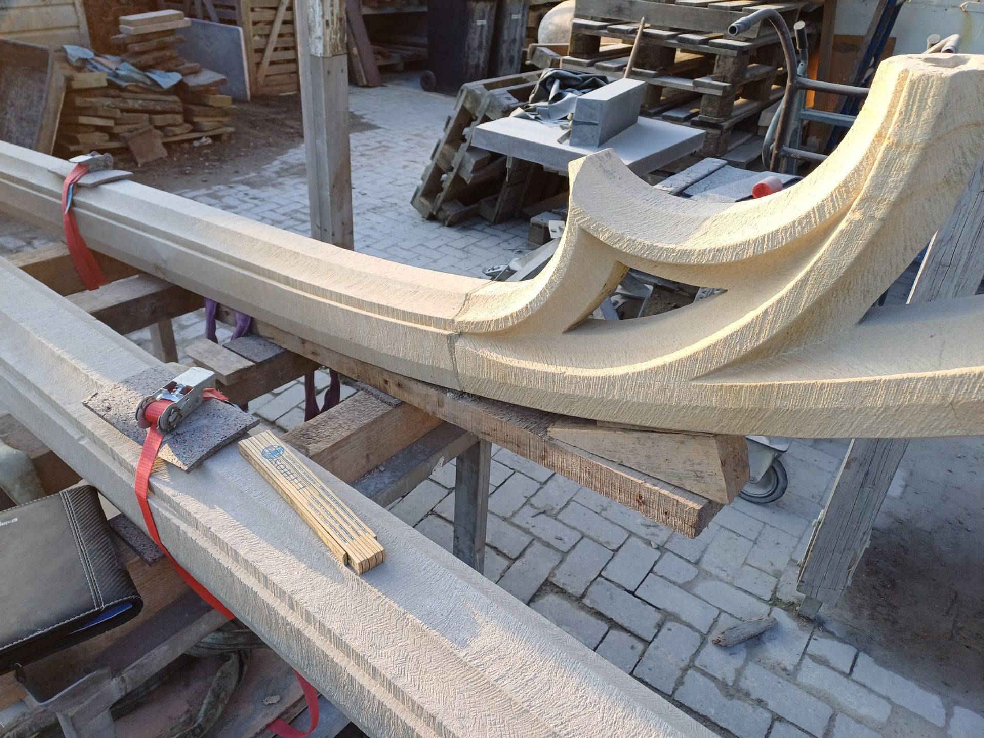 Auf einem Tisch liegt ein halber gotischer Steinbogen