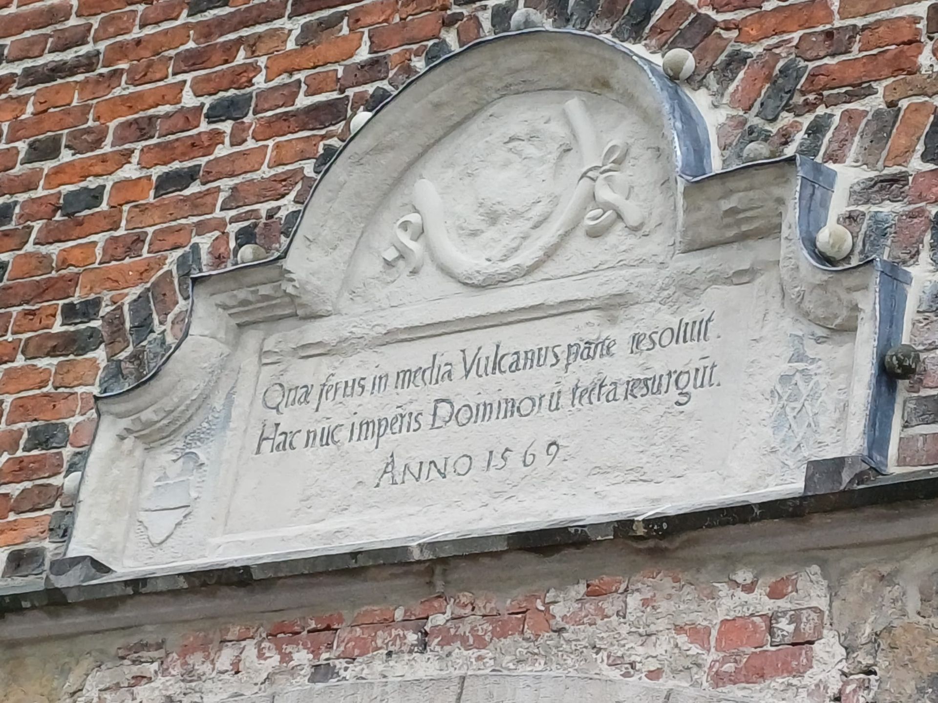 Eine Ziegelmauer mit einer Steintafel darauf