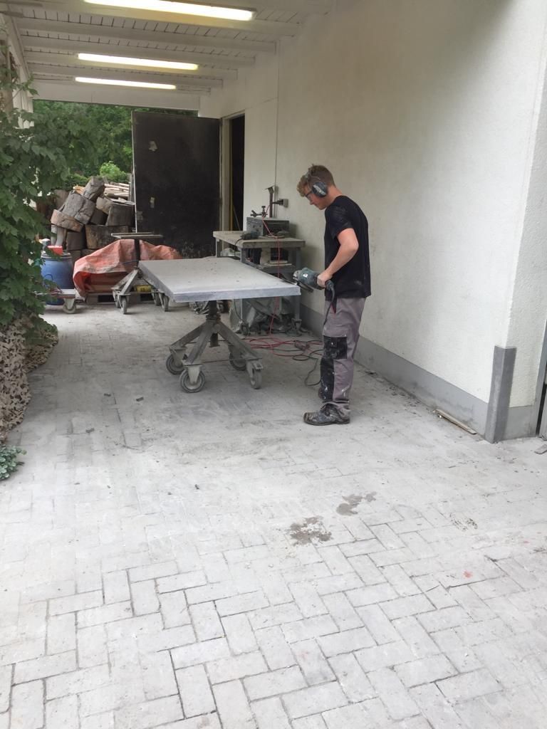 Ein Mann mit Hörschutz steht neben einem Tisch.