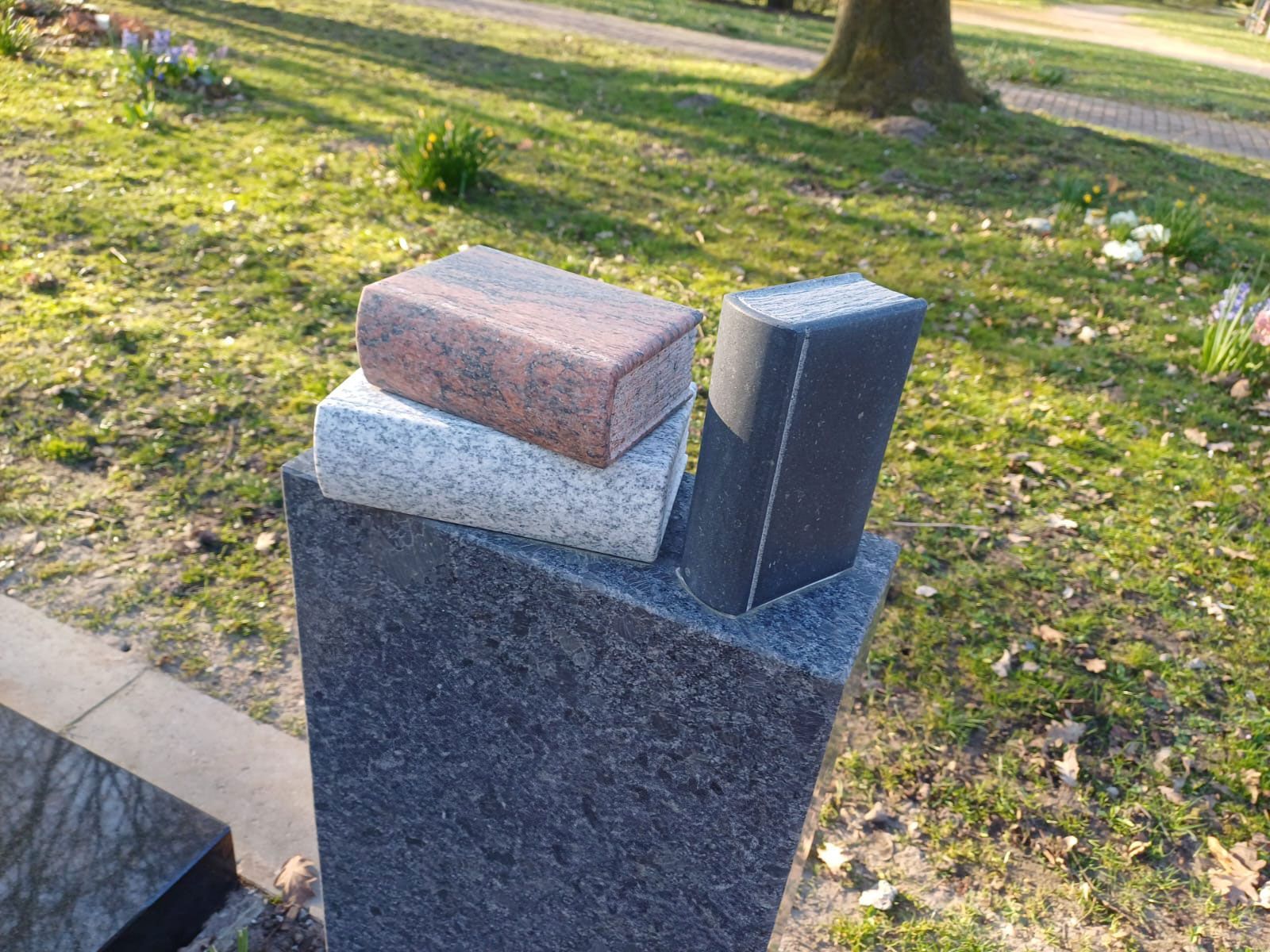 Grabdenkmal mit gemeißelten Büchern darauf