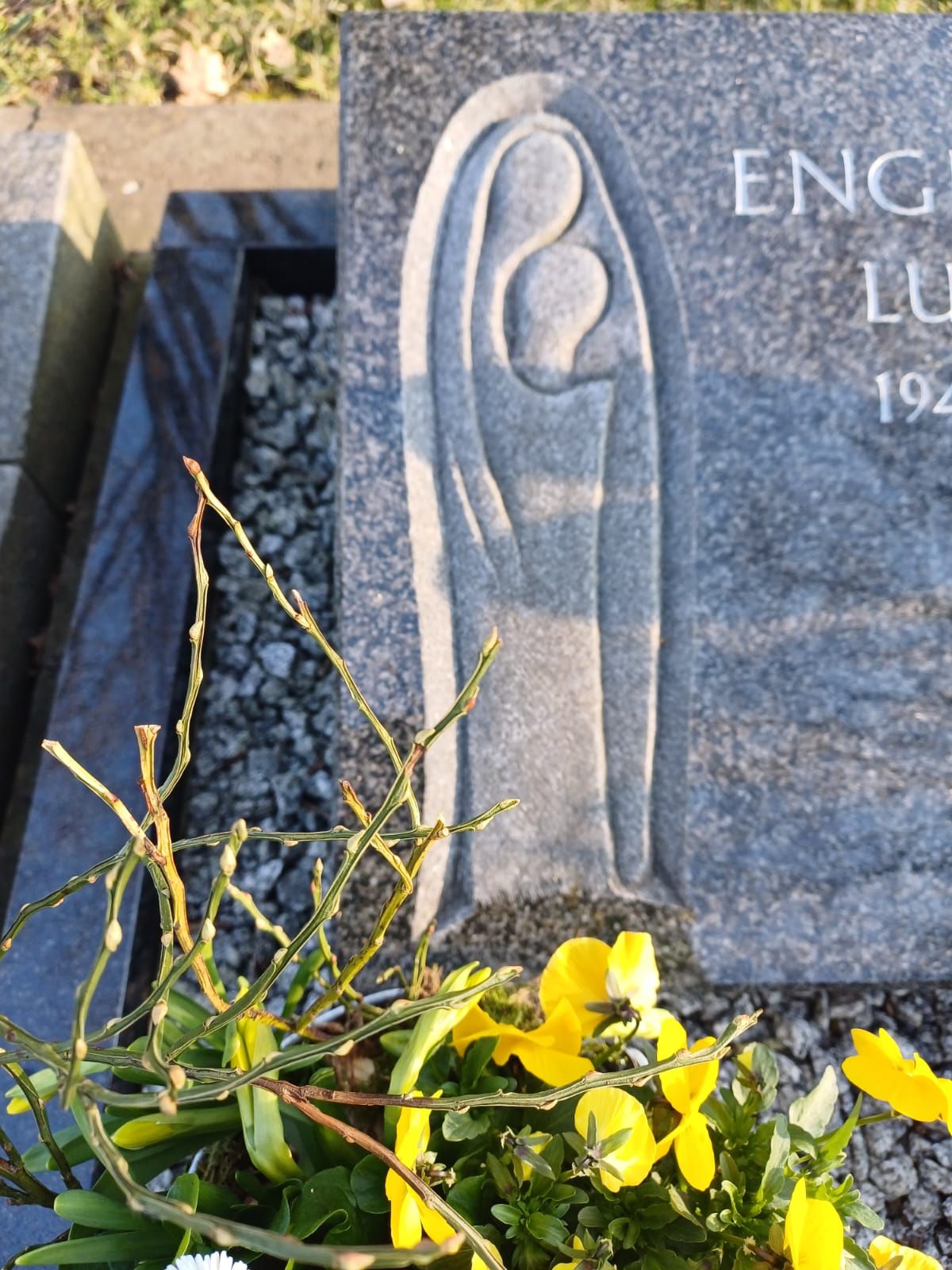 Ein Grabstein mit einer Statue einer Frau und eines Kindes darauf