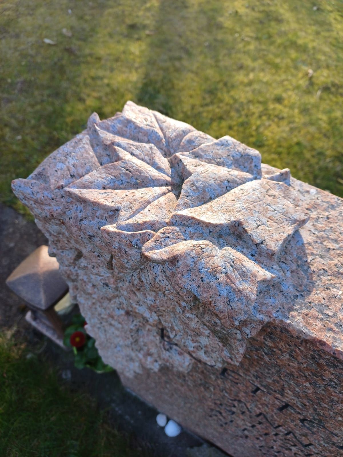 Eine Nahaufnahme einer Steinskulptur mit eingemeißelten Blättern.