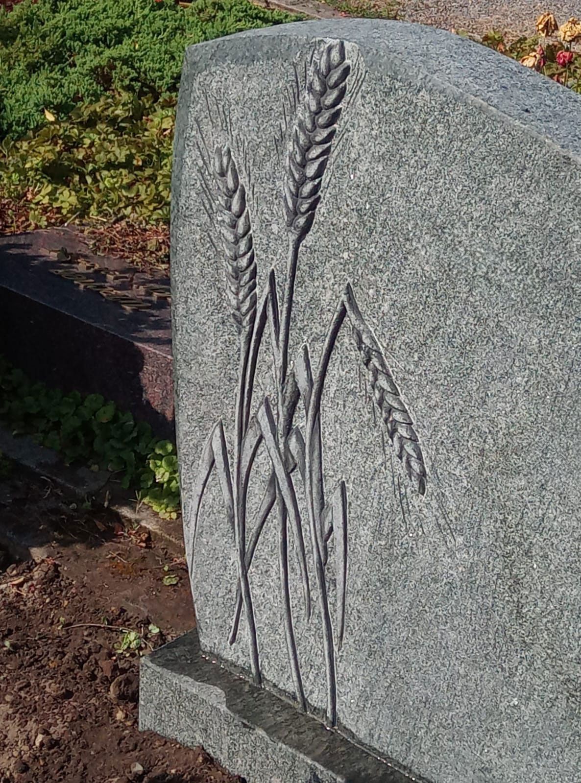 Ein Grabstein mit zwei eingemeißelten Weizenähren.