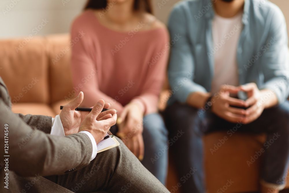 Coppia in seduta con lo psicologo, mentre discute di problemi relazionali su un divano.