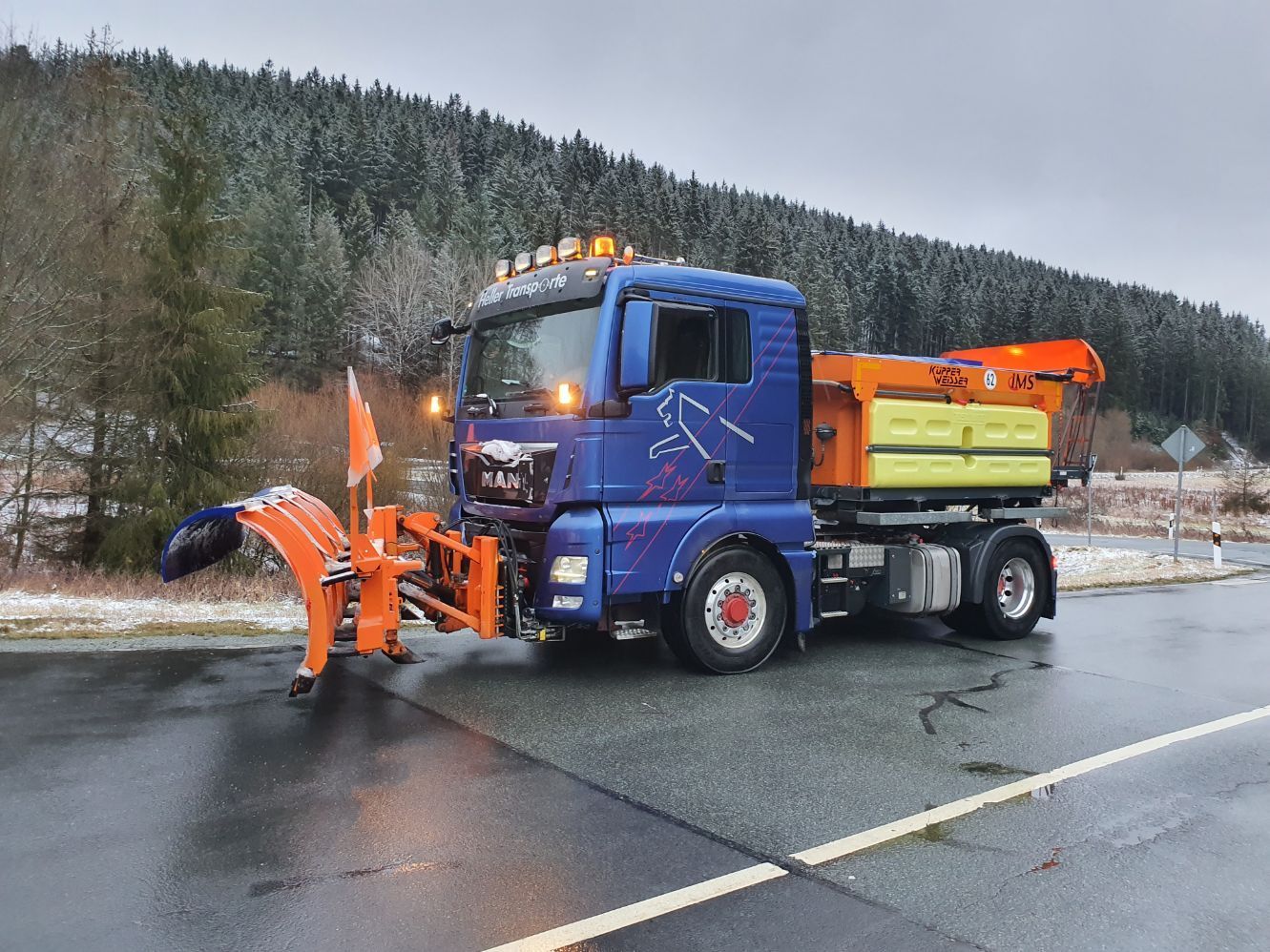 Transporter mit orangefarbenem Schneeschieber