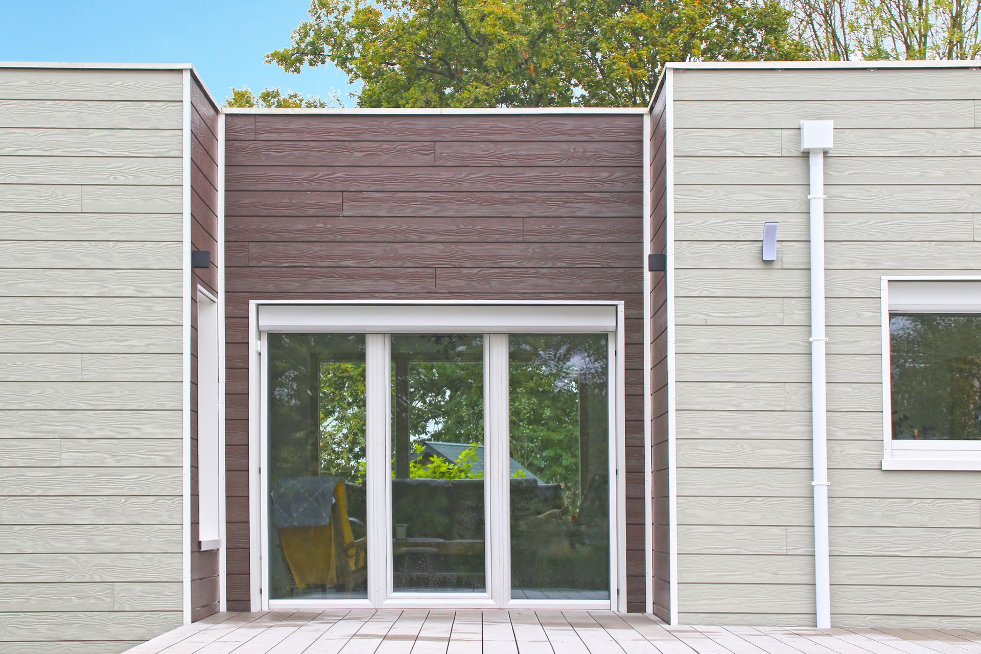 Sièges et tables sur la terrasse en bois d'une habitation