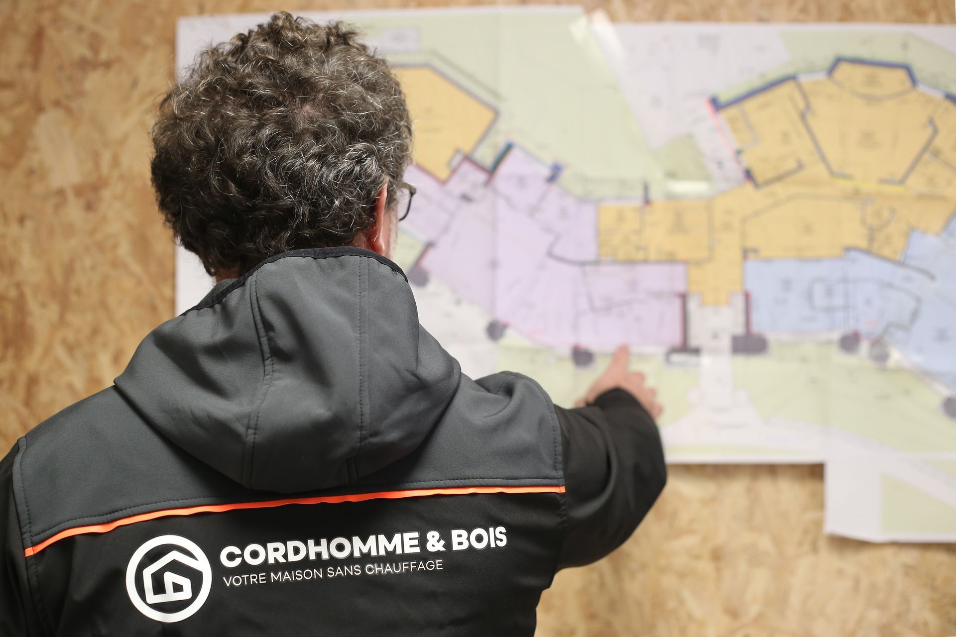 Monsieur Cordhomme de dos montrant un plan cadastral
