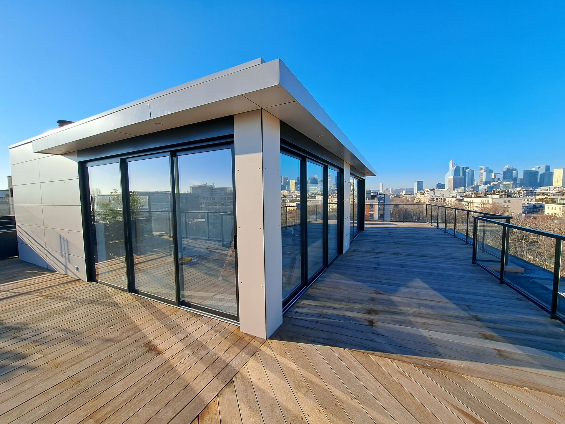 Maison aux grandes baies vitrée sur un toit avec vue sur la ville