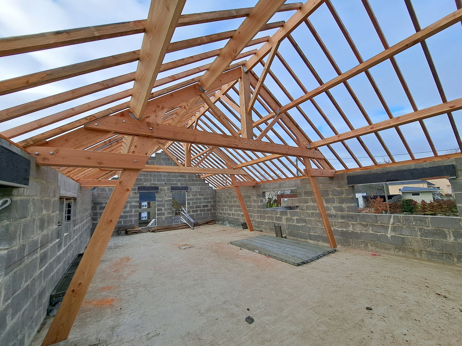 Vue du dessous d'une charpente en train d'être posée
