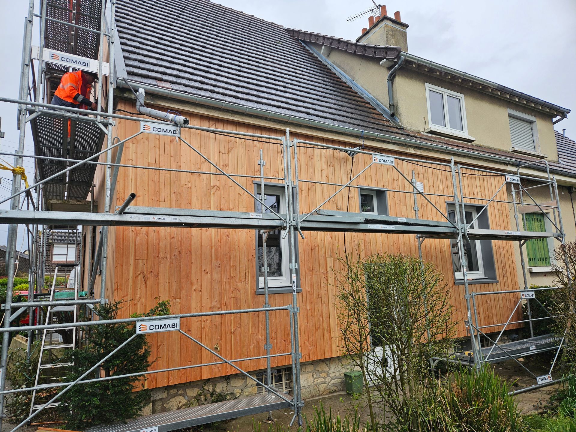 Échafaudage devant une façade de bardage en bois d'une maison