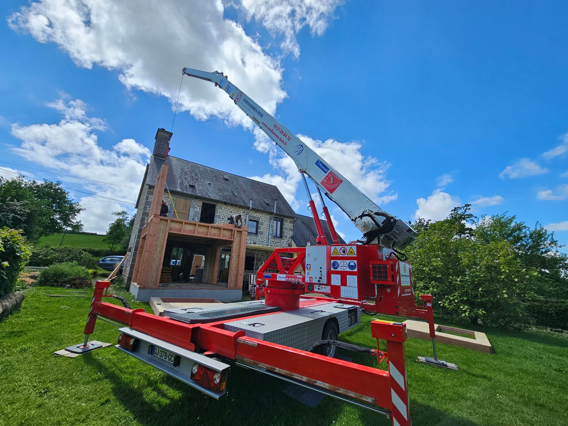 Une grue devant la construction d'une extension de maison