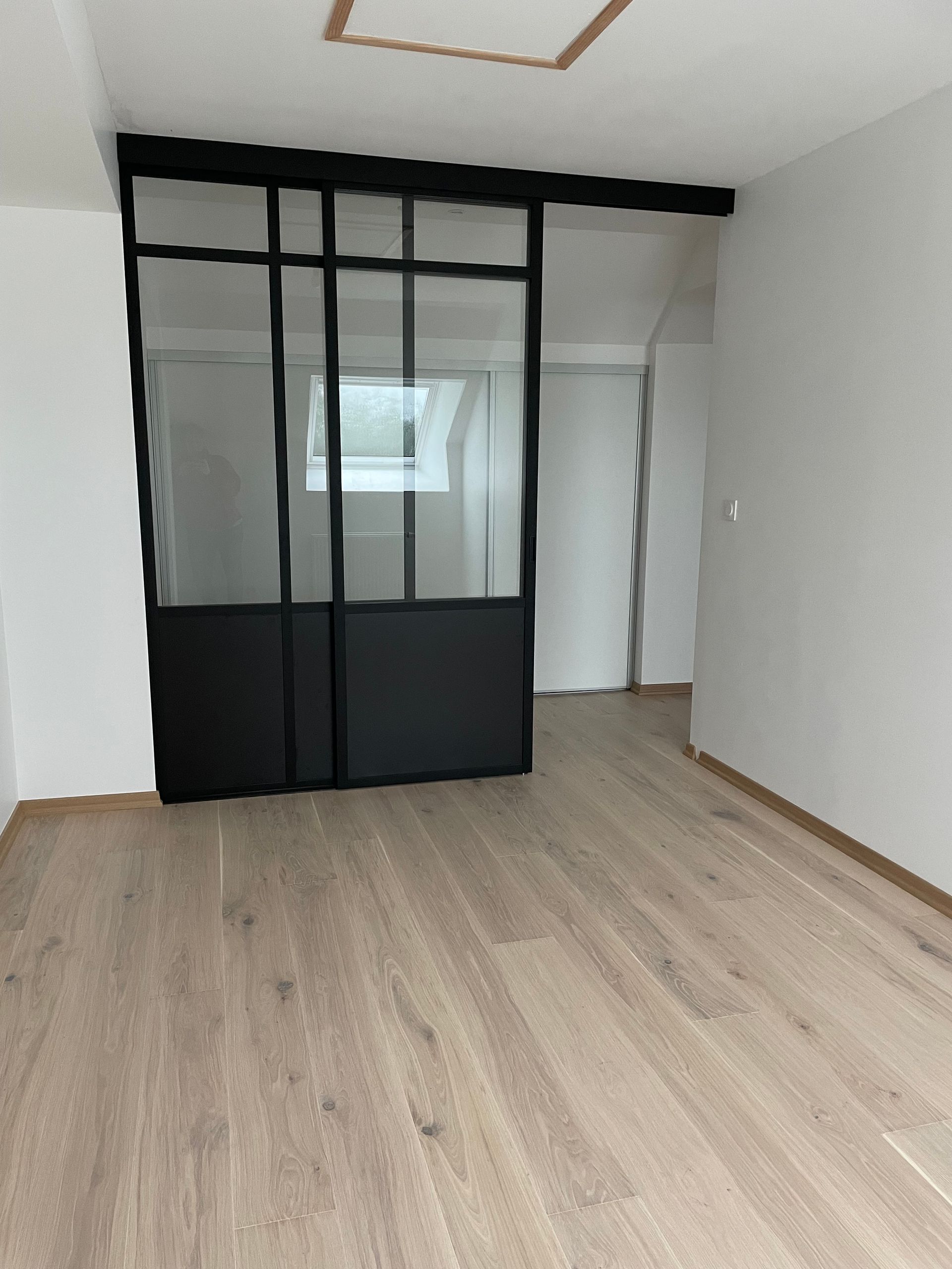 Cloison et porte coulissante avec grandes vitres d'une pièce d'intérieur