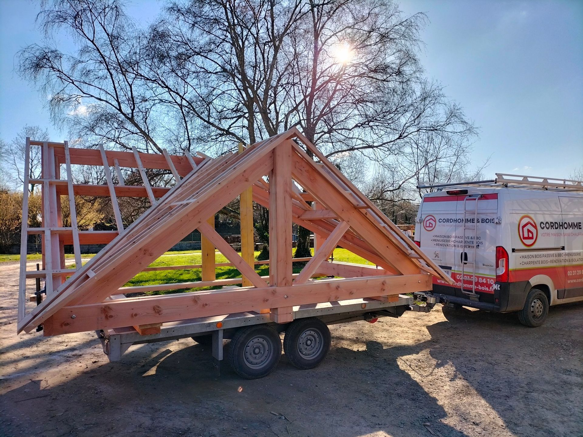 Une charpente tracté par une camionnette de l'entreprise Cordhomme & Bois