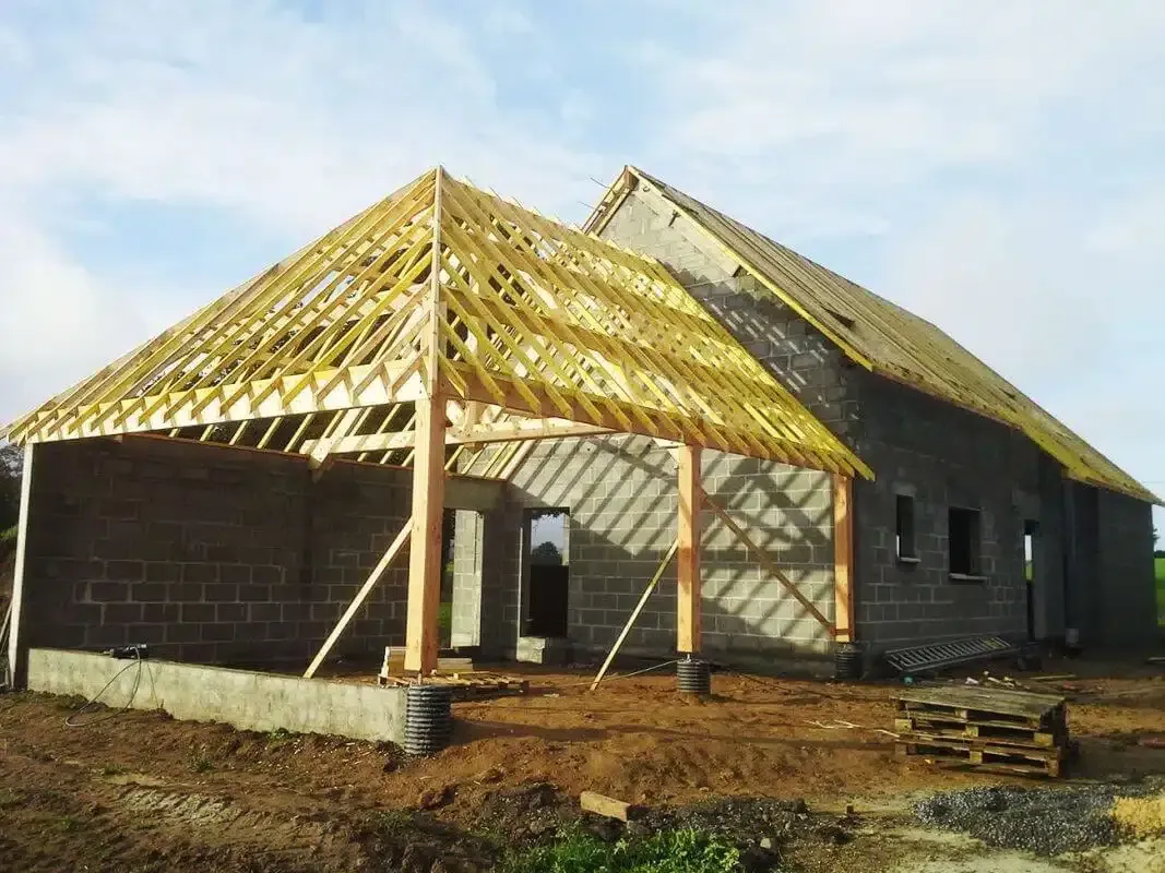 Construction d'une extension en bois collée à une maison en construction