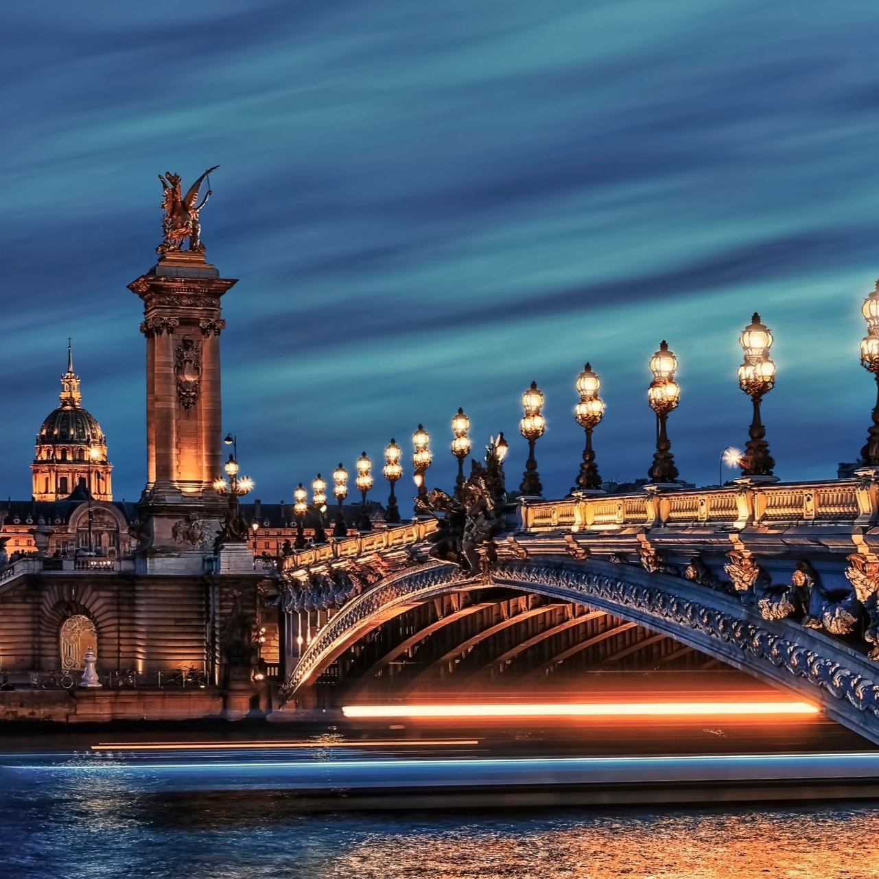 Le pont Alexandre III illuminé à Paris au crépuscule.