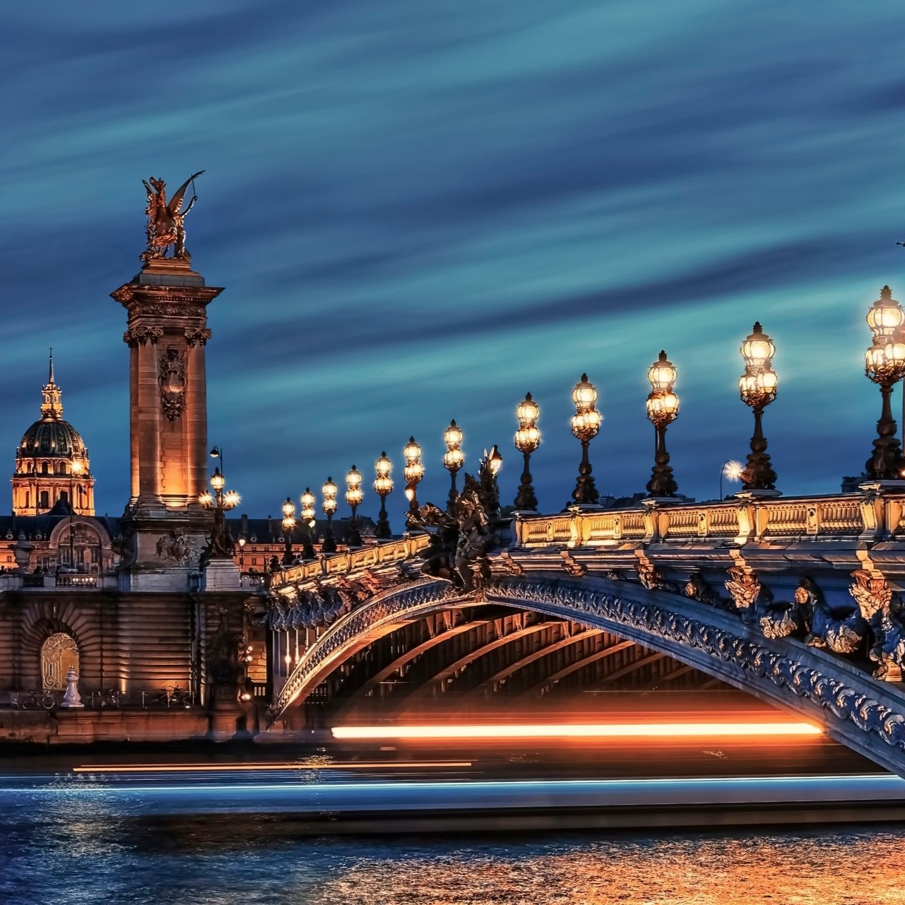 Vue nocturne du pont Alexandre III à Paris, illuminé, enjambant la Seine.