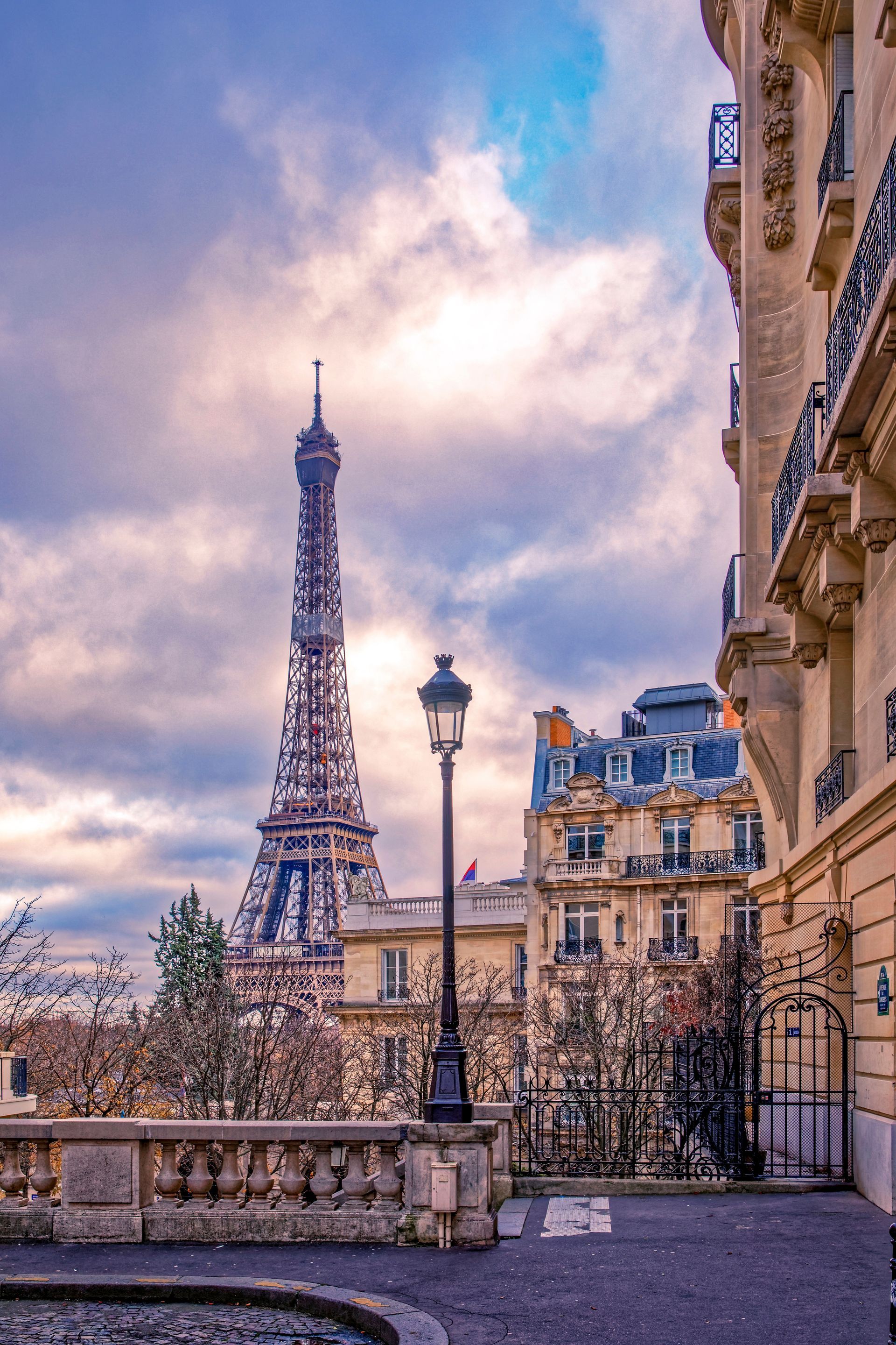 La tour Eiffel et les immeubles parisiens sous un ciel nuageux.