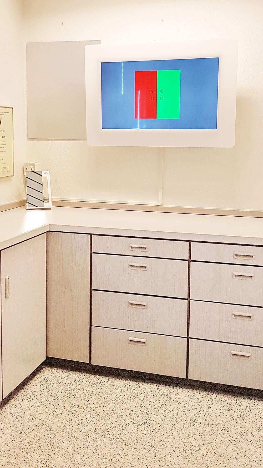 Eine Küche mit weißen Schränken und einem Fernseher an der Wand