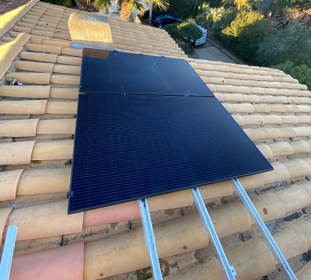 Deux panneaux solaires sont placés sur un toit en tuiles.