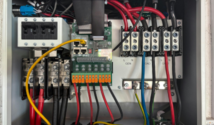 Un gros plan d'un boîtier électrique avec beaucoup de fils et de connecteurs.